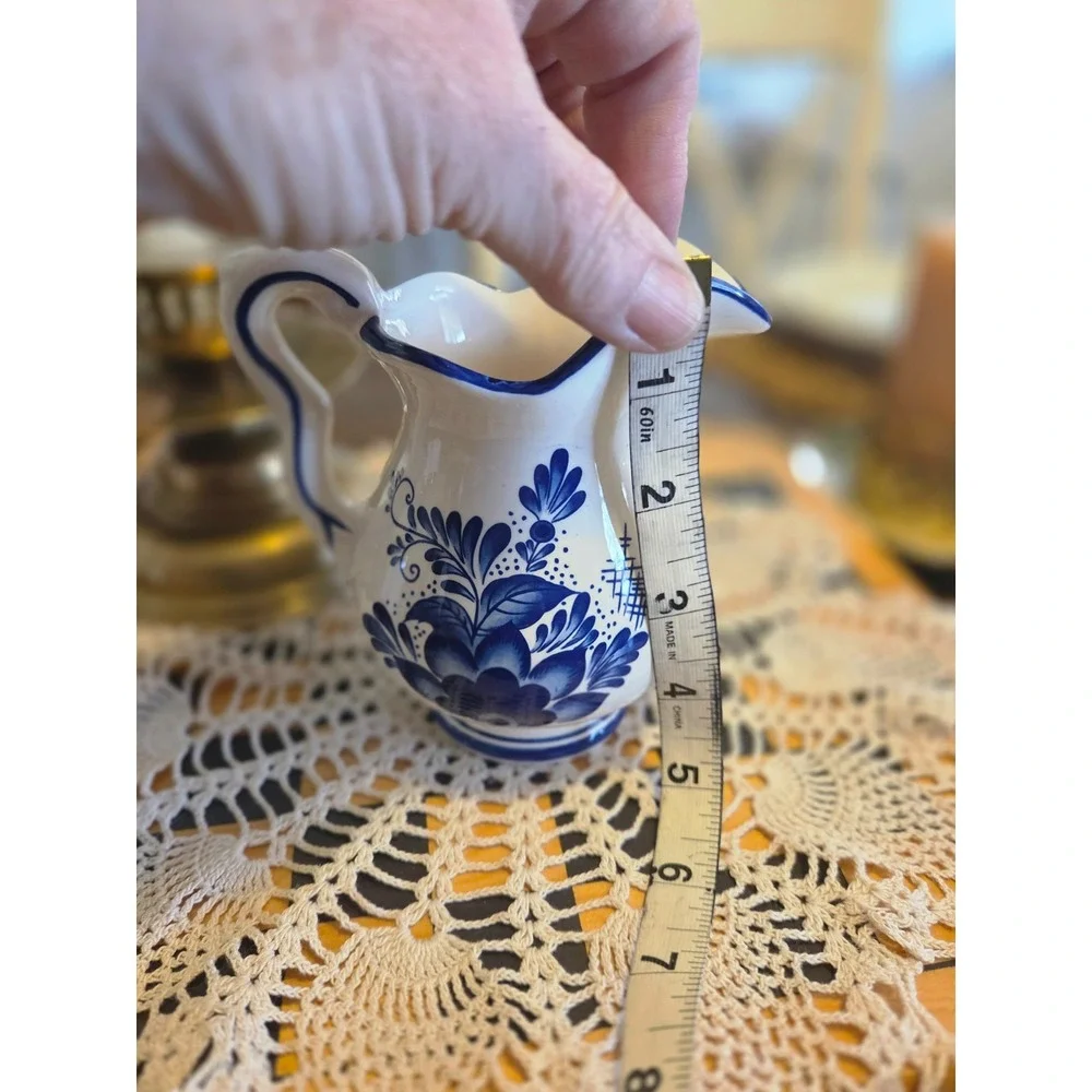 This is a vintage Delft Blue hand-painted ceramic creamer pitcher And Bowl/plate